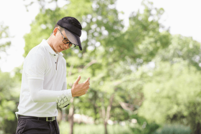 A golfer holds his wrist. Having wrist pain after golf could be caused by a number of conditions.